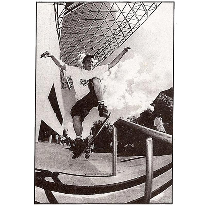 Vintage photograph of Dean in mid air before landing on a handrail off a set of stairs - Ollie Boardslide on a Handrail.
