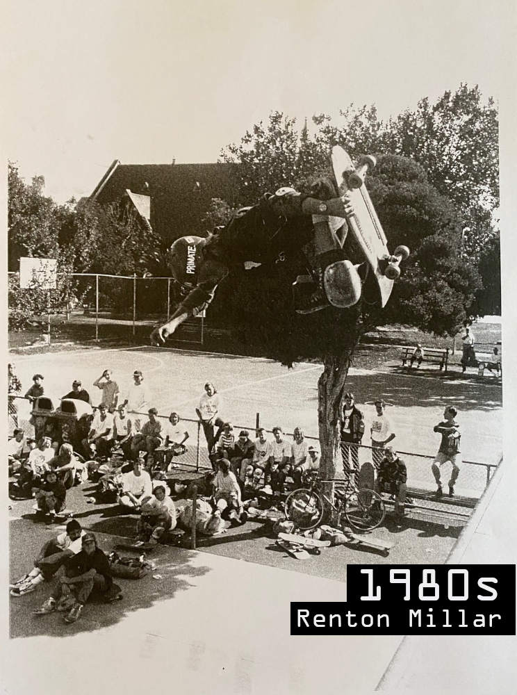 Black and White vintage style photo of Renton Millar doing an air above Prahran Vert Ramp in the 80s.
    There are 25 to 30 people on the ground watching Renton. The basketball court can be seen in the background.