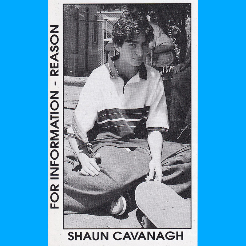 Sean Kavanagh wearing very baggy denim jeans with Etnies shoes and a striped polo style t-shirt.
    He is smiling a little - holding a backpack and his skateboard.